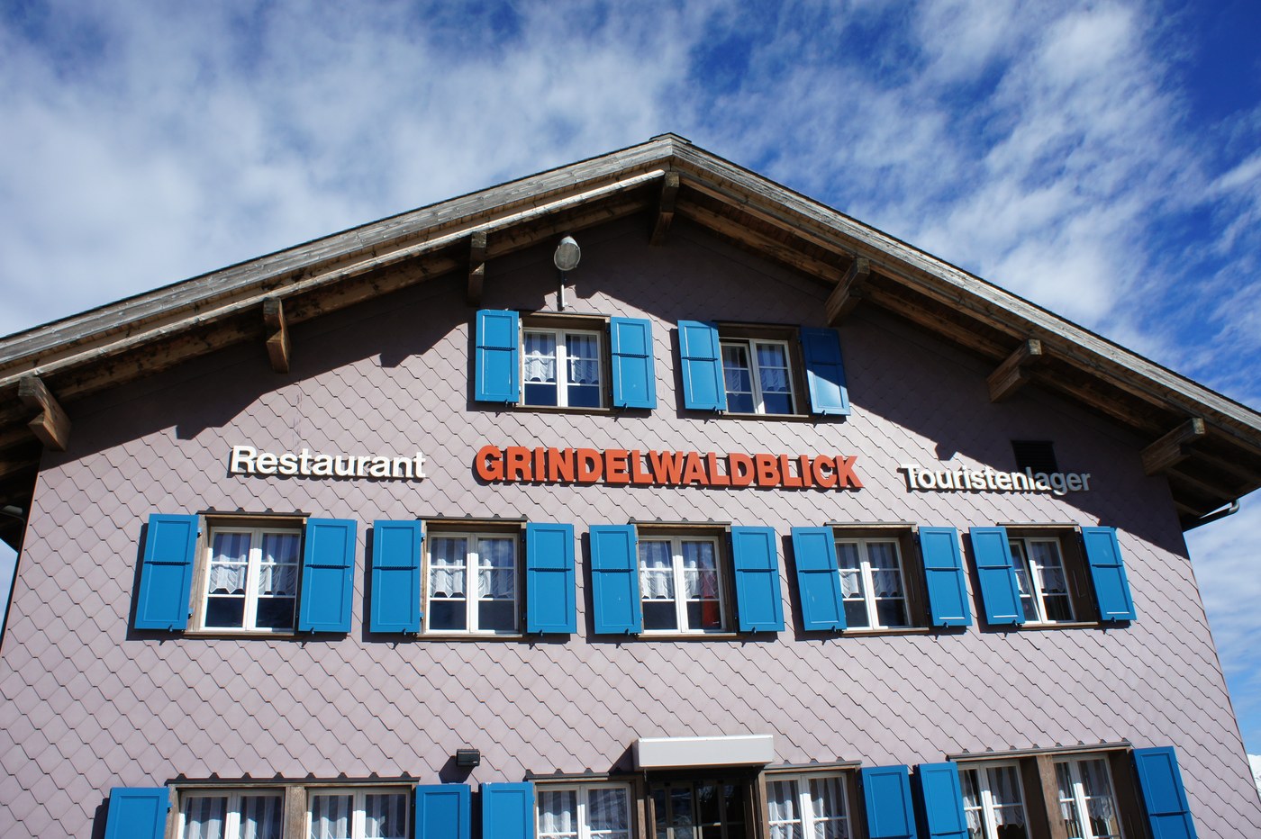 そのレストラン「Restaurant GRINDELWALDBLICK」。青い鎧戸と木の壁の、いかにも山小屋らしいたたずまい。名前のとおり、
