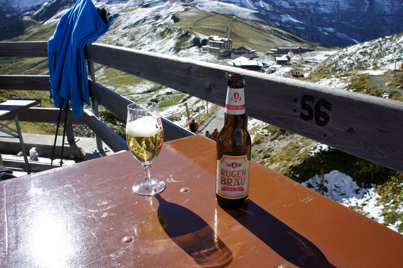 歩いたあとの一杯は格別。地ビール「RUGEN BRÄU（ルーゲンブロイ）」を、雪の峰を眺めながら。グラスに山が映り込みそうな、贅沢な時間。