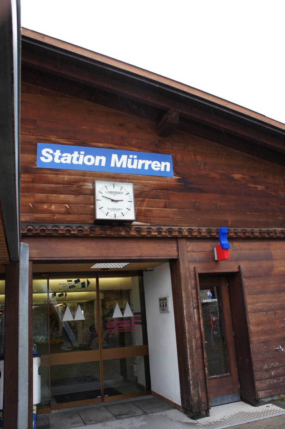 こちらがミューレンの駅(Station Mürren)。青い駅名標と、ロンジンの時計。木をふんだんに使った、山の村らしい駅舎だ。ここから、村